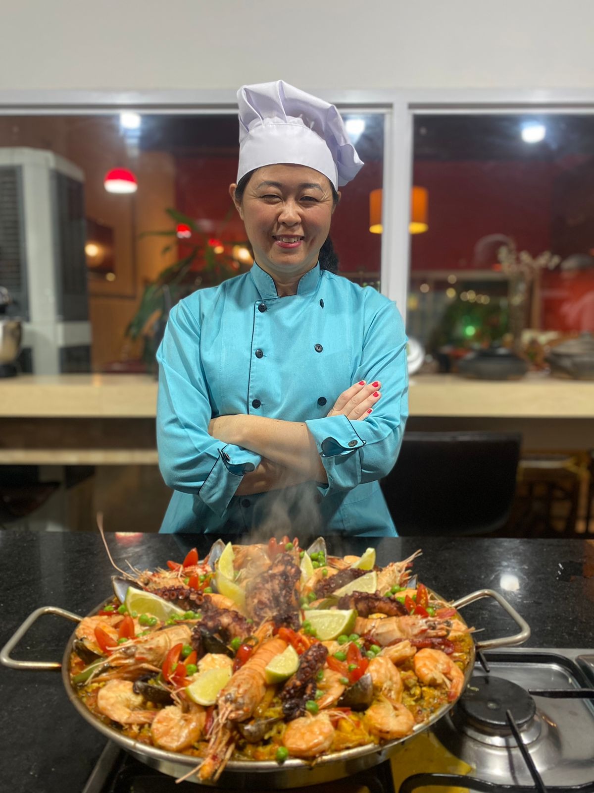 Chef Thaís Okamoto ensinando em aula de culinária