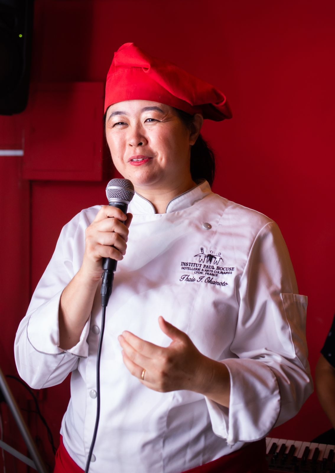 Chef Thaís Okamoto palestrando em evento de gastronomia